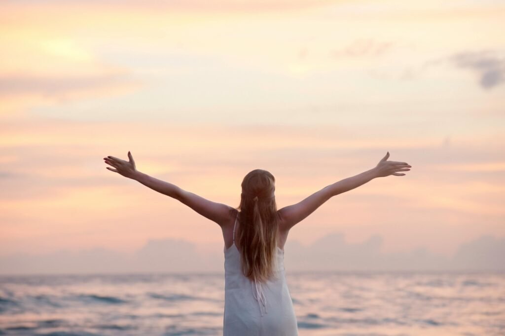 A woman enjoying a serene sunset motivated and happy LUCABUSO